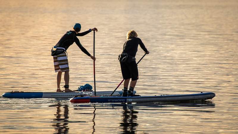zwei Menschen beim Stand up paddling