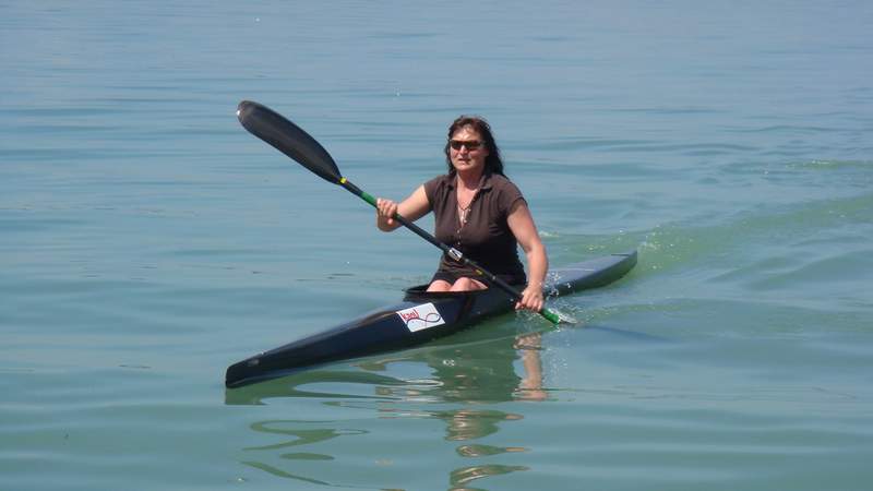 Birgit Fischer sitzt im Kanu auf dem Wasser und paddelt.