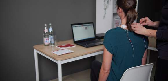 Einer Mitarbeiterin werden Elektoren für die Messung aufgeklebt