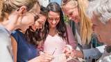 Frauen spielen City Codes und schauen ins Rätselheft