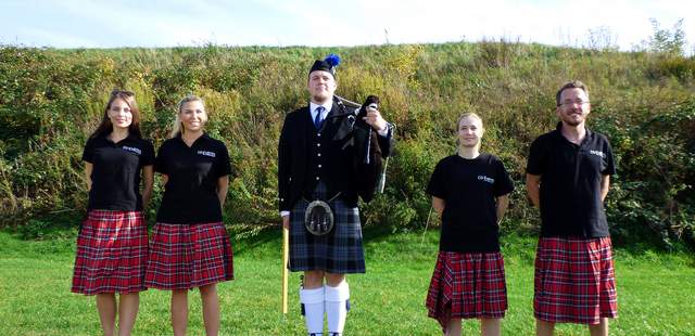 Highland Games als Team-Event Fünf Personen in einem schottischen Outfit