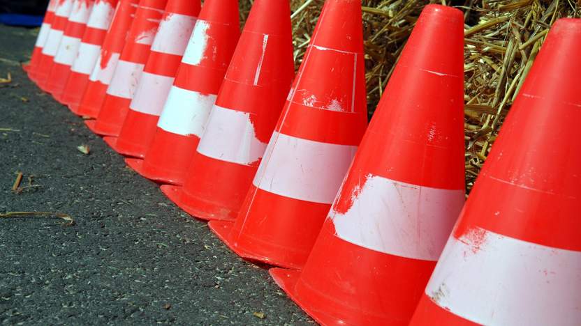 Rote Absperrkegel stehen in einer Reihe