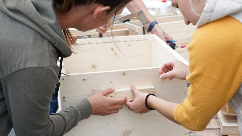 Teammitglieder fertigen aus Holz einen beheizbaren Bienenstock beim Teamevent BEE A TEAM