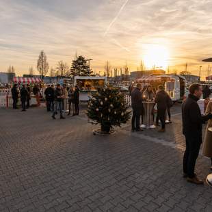 Pop-up Weihnachtsmarkt für Firmen mit Gästen, Marktständen und winterlicher Atmosphäre