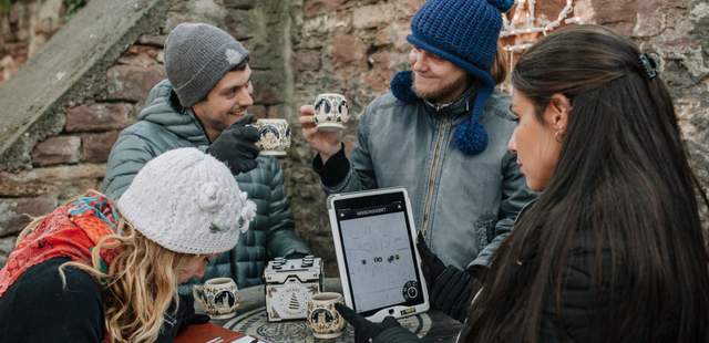 Gruppe feiert gemeinsam mit heißen Getränken auf einem Weihnachtsmarkt