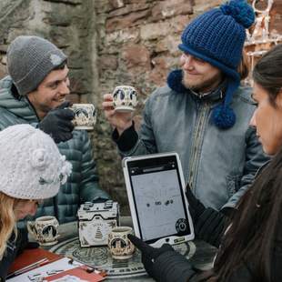 Gruppe feiert gemeinsam mit heißen Getränken auf einem Weihnachtsmarkt