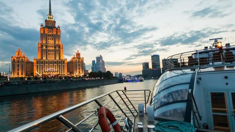 Blick von der weißen Yacht auf der Moskwa auf beleuchtete Gebäude in Moskau