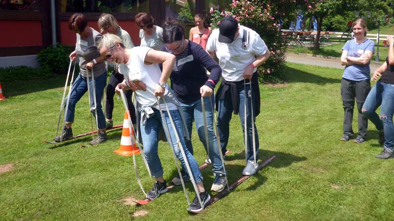 Zwei Teams bei Teambuilding Aktion Team-Ski auf dem Rasen beim Event Dream-Team