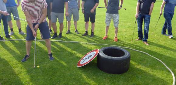 Mann puttet in einen Rennreifen beim Rahmenprogramm Fun Golf