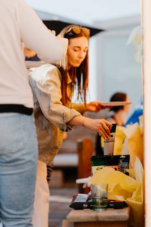 Teilnehmer greift im Workshop nach Farbe
