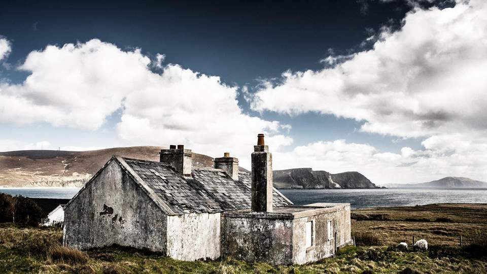 Blick auf ein traditionelles Cottage an der Küste Irlands