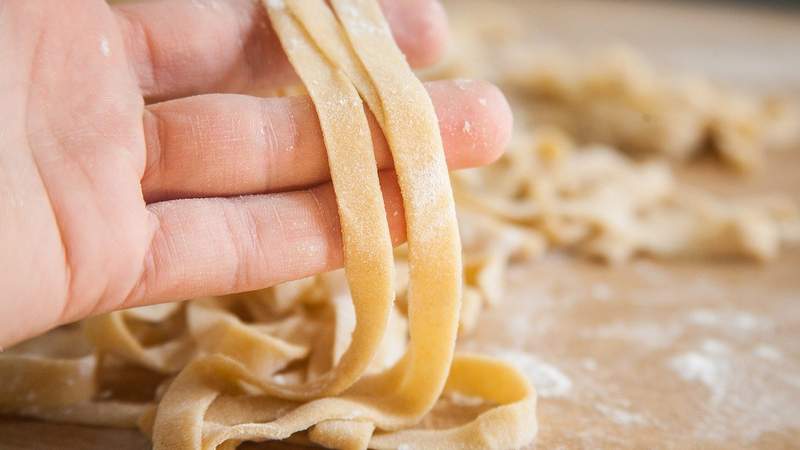 Bemehlte Hand mit hausgemachter italienischer Pasta