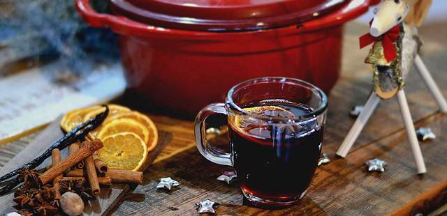 Glühweinkochen als Teamevent roter Topf mit Glühwein, Orangen und Zimtstangen