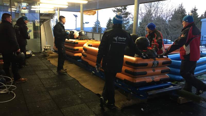 Gäste sitzen im Bob und Betreuer stehen im Startbereich der Rennschlitten- und Bobbahn Oberhof