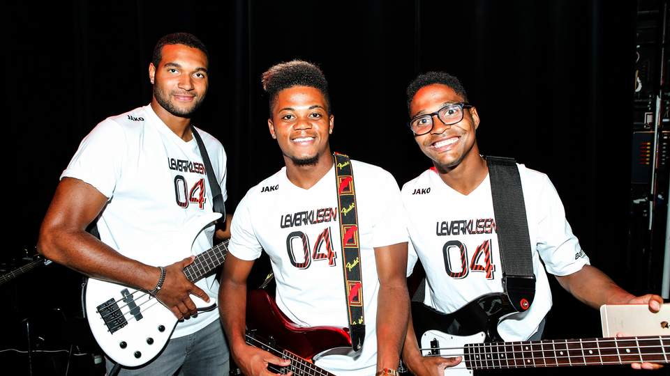 Drei Teilnehmende halten Gitarren bei einem Teamevent und erleben gemeinsames Teambuilding durch Musik, Zusammenarbeit und Bühnenmoment ohne Vorkenntnisse.