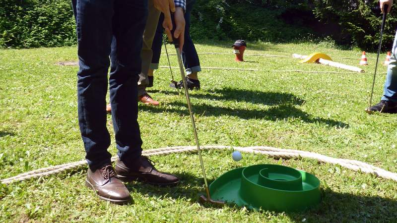 Golfball fliegt ins Loch beim Fun Golf Event auf dem Rasen