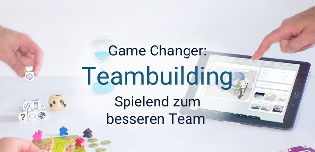 Das Bild zeigt einen weißen Tisch mit Spielutensilien: Eine Hand stapelt Würfel zu einer Pyramide, Spielplättchen mit Meeple-Figuren, ein Tablet mit dem Serious Game "Eternal Ice" und Spielkarten am unteren Bildrand.