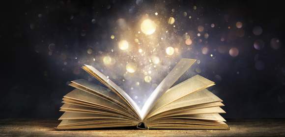 Aufgeschlagenes Buch mit magischem Staub