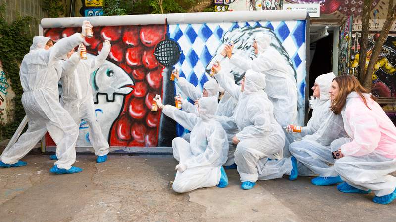 Graffiti-Künstler vor Ihrem Kunstwerk in Berlin