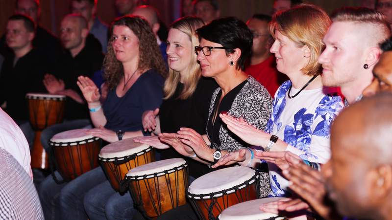 trommelnde Mitarbeiter beim Teamevent