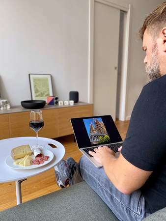 Der Gast sitzt auf dem Sofa mit seinem Laptop.