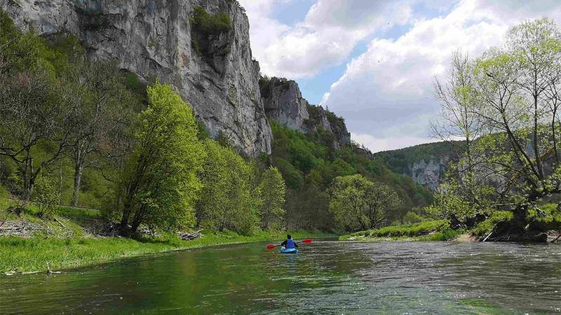 einzelner paddler vor dem felsmassiv schaufels im oberen donautal