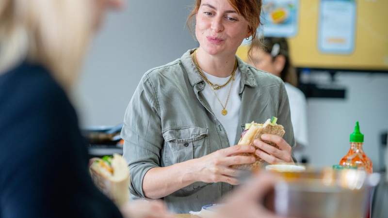 Teilnehmerin genießt selbst zubereitetes Essen bei einem Teambuilding Kochworkshop
