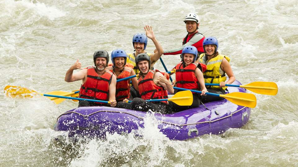 Teambuilding Menschen in einem Schlauchbot beim Teambuilding