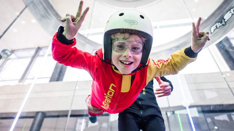 Kinder, die im Windkanal fliegen