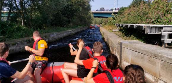 Rudernde Menschen in einem Raftingboot