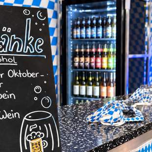 Pop-up Oktoberfest für Firmen Getränkestation mit Oktoberfestbier, Wein und blau-weißer Dekoration beim Pop-up Oktoberfest für Unternehmen