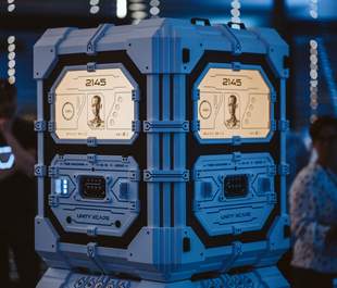 Eine futuristische blaue Zeitmaschine mit der Aufschrift 2145 und Unity Xcape, beleuchtet von blauem Ambientelicht, zeigen beleuchtete Panels mit KI-Gesicht und Time Machine Beschriftung im mobilen Escape Room