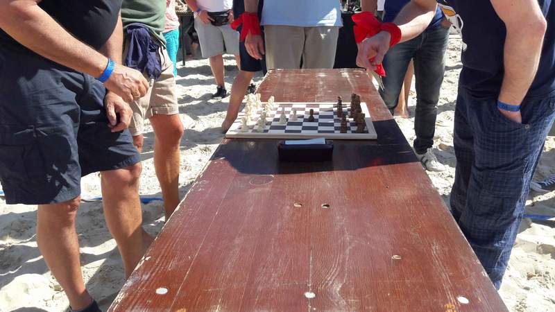 Mehrere Personen spielen Beach-Olympiade-Schach