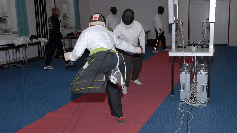 Zwei Herren in Fechtkleidung fechten gegeneinander