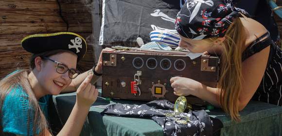 2 Frauen versuchen die Escape Box der Piratenschatzsuche zu öffnen