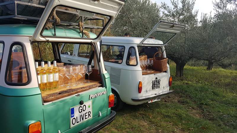 Oldtimer-Busse mit geöffnetem Kofferraum inkl. Weinflaschen für die Weinverkostung