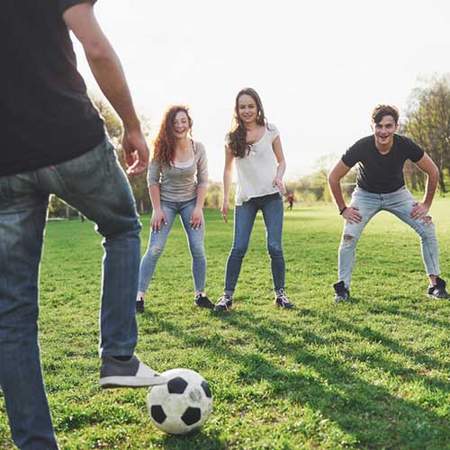 Mehrere Personen auf einem Rasen mit Fußball