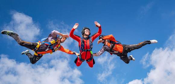 3 Personen beim Fallschirmsprung