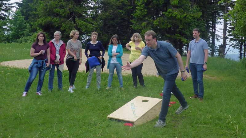 Mann wirft Maissäckchen beim Betriebsausflug mit Teamevent Fun Golf