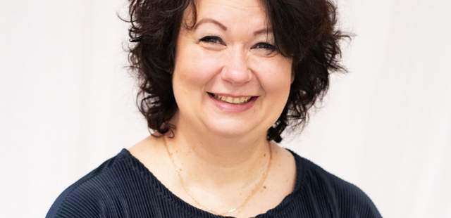 Ansprechpartnerin mit dunklen Locken und sympathischen Lächeln