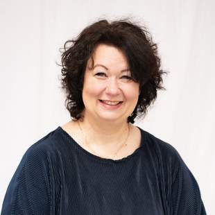 Ansprechpartnerin mit dunklen Locken und sympathischen Lächeln