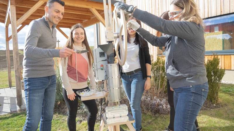 Personen bedienen gemeinsam den Plasticpreneur Extrudor