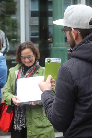 Stadtführungsstation wo Mann grüne Karte hochhält