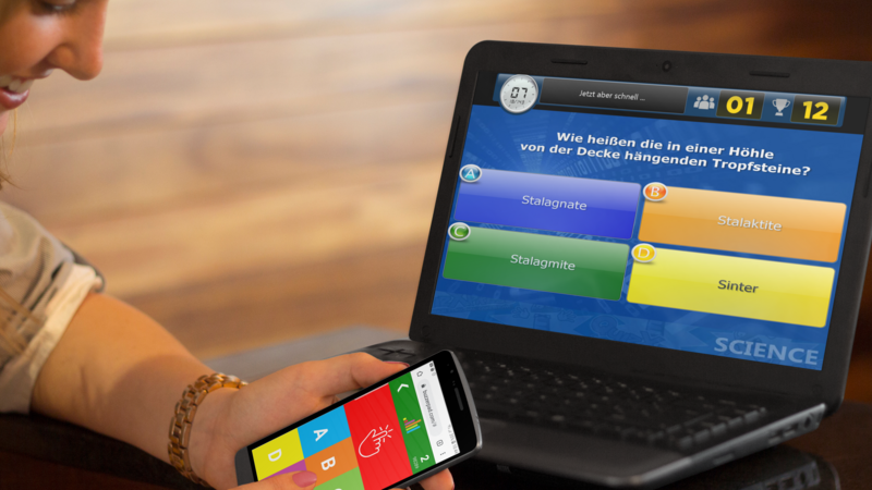 Frau spielt Quiz CONNECT über Handy und Laptop