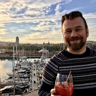 Der Reiseführer trinkt ein Glas Sangria auf einer Dachterrasse.