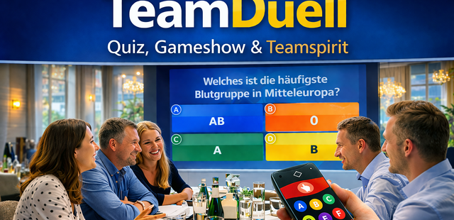 5 Personen sitzen am Tisch und ein Mann hält eine Fernbedienung ins Bild. Im Hintergrund ist eine Leinwand zu sehen. Sie spielen das Quiz TeamDuell.