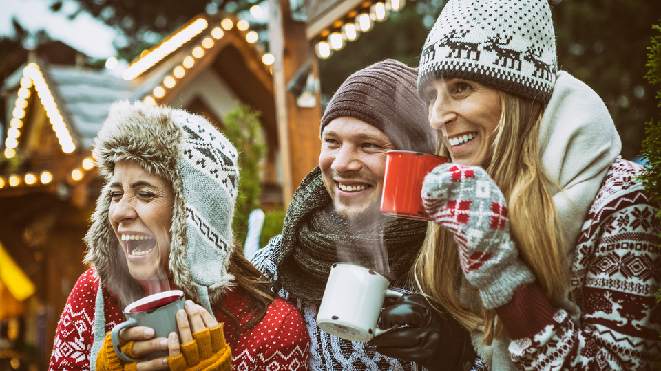 Menschen mit Glühwein auf dem Weihnachtsmarkt
