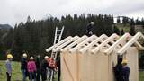 Hüttenbau als Teambuilding Team baut gemeinsam eine Holzhütte beim Teambuilding