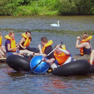Teilnehmer paddeln auf dem Wasser mit selbstgebautem Floß