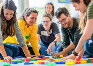 Junge Menschen bei einem Team-Spiel mit Bausteinen